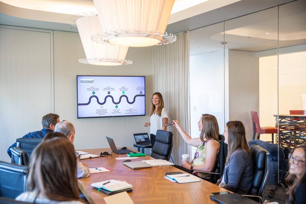 Workplace Strategies team meeting in a conference room looking at a presentation